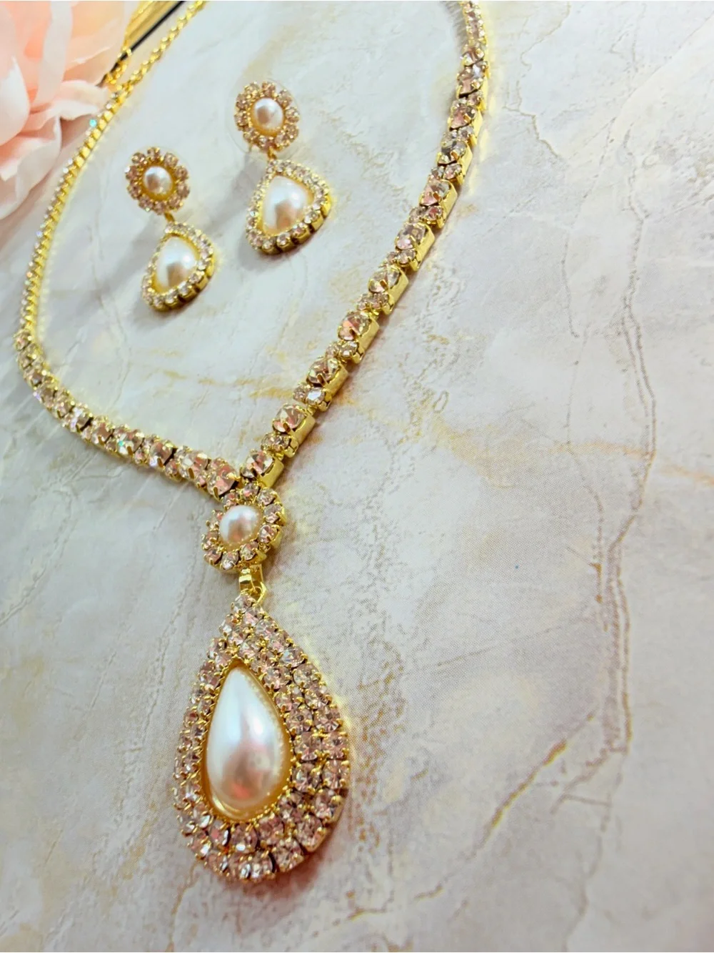 Elegant gold-tone necklace with earrings featuring a white teardrop pearl pendan